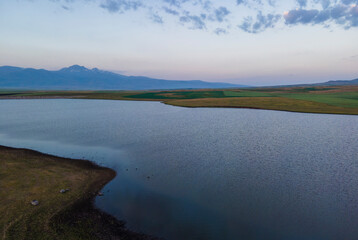 Beautiful sunrise time lapse sky and clouds, panoramic view on the lake and mountains.