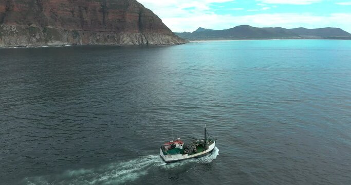 Aerial view. Fishing boats trawler ship sailing on ocean on sunset.