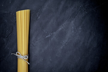 A single bunch of pasta against a dark slate of slate