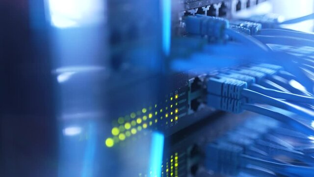 Close-up view of modern internet network switch with plugged ethernet cables. Blinking lights on internet server. Concept of data center. Cloud computing and telecommunications