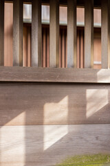 寺の木製の塀の格子にさす斜めの光と影