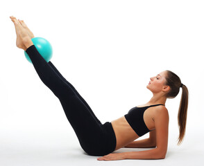Fototapeta na wymiar Young fit adult woman doing yoga exercise workout with gymnastics ball.