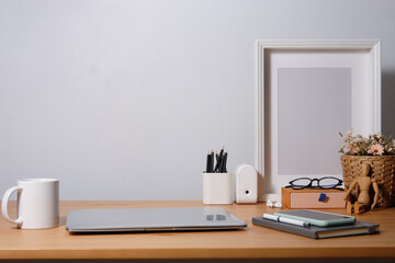 Modern workspace desk and copy space book, plant and coffee cup on wood desk.