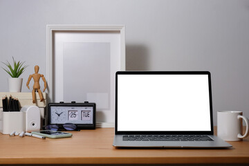 Modern workspace with laptop computer, books, picture frame and coffee cup.