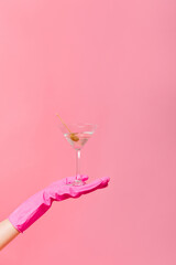 Photo of martini glass with olive in hand on pink background