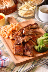 Grilled bone-in pork chop on wooden board    