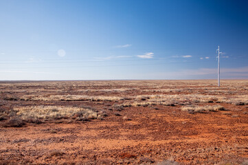 Bright colours & textures of the rocky desert with power lines on the horizon. South Australia.