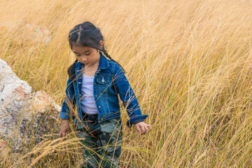 Naklejka na ściany i meble asian girl playing alone in grassland on mountain during summer