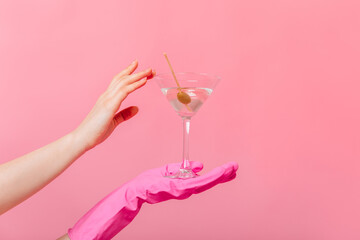 Shot of martini glass and olives in hands of woman