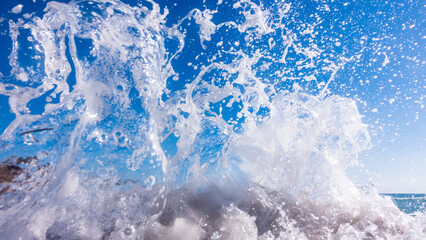 Fototapeta na wymiar A surge of surf waves on a rocky shore