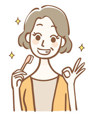 歯ブラシを持ってOKサインをする中年女性