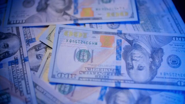 American 100 dollar banknotes are rotating on the table close up. Concept of saving money, monetary inflation and cash flow.