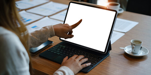 Mockup image of a black tablet with white blank screen on wooden desk