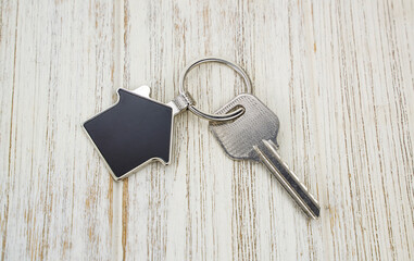 key chain with house symbol and keys on wooden background,Real estate concept
