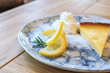 Lemon tart with slice of lemons. Enjoy fresh baked dessert in restaurant. Closeup shot of little sweet decorative cake