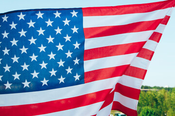 Fototapeta premium Us flag hanging in front of the forest