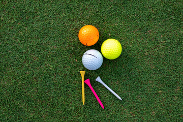 A golf glove , white golf ball and tee put on green grass of golf course ,This golf objects for play	
