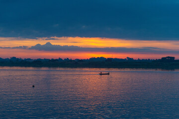 Naklejka premium The sunrise view on the Mekong River overlooks the Laos side and sees fishermen driving their fishing boats at dawn.