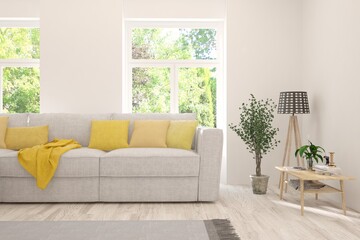 Fototapeta premium White living room with sofa and summer landscape in window. Scandinavian interior design. 3D illustration