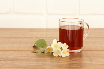 Glass cup of tea with white jasmine flowers