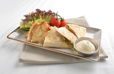 Mexican pizza wrapped with egg, sausage, bacon, ham and salad dressing in white background halal breakfast menu