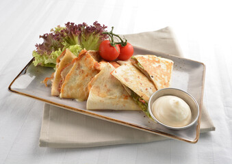 Mexican pizza wrapped with egg, sausage, bacon, ham and salad dressing in white background halal breakfast menu