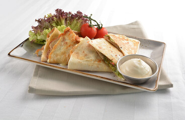 Mexican pizza wrapped with egg, sausage, bacon, ham and salad dressing in white background halal breakfast menu