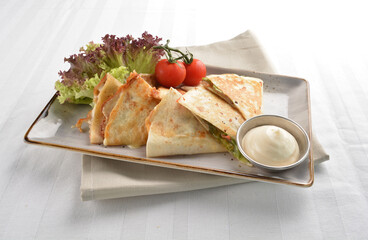 Mexican pizza wrapped with egg, sausage, bacon, ham and salad dressing in white background halal breakfast menu