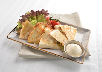 Mexican pizza wrapped with egg, sausage, bacon, ham and salad dressing in white background halal breakfast menu