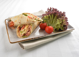 western tortilla wrapped with ham, cheese and vegetables in white background halal breakfast menu