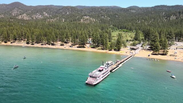 MS Dixie ll ferry boat on the dock as a drone flies counter clockwise from the back of the ferry to the front with north  Lake Tahoe as the background.