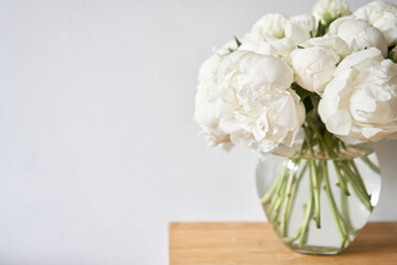 White peonies in a glass vase. Beautiful peony flower for catalog or online store. Floral shop concept . Beautiful fresh cut bouquet. Flowers delivery