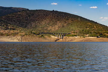 Mountain landscape with a lake and a bridge.