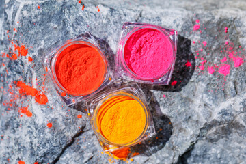 Banks with dry colored pigments. Tools for nail design in a manicure cabin. Beautiful neon paints.
