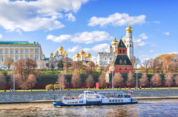 Towers and temples of the Kremlin and a pleasure ship on the Moskva River in Moscow
