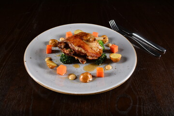 marinated grilled duck leg confit with vegetables and sauce main course in dark background western halal menu