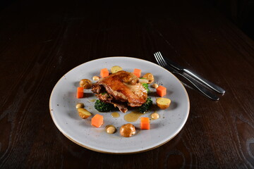 marinated grilled duck leg confit with vegetables and sauce main course in dark background western halal menu