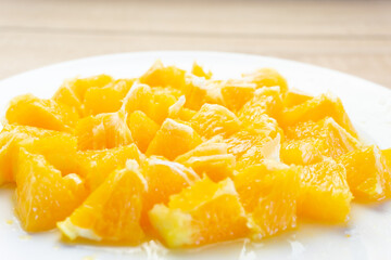 Close-up of fresh cut oranges on a white plate with the background out of focus
