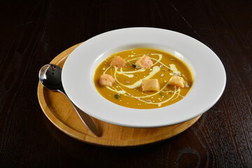 fresh cook golden yellow pumpkin thick soup with bread spread bites and cream appetiser in dark background western halal menu