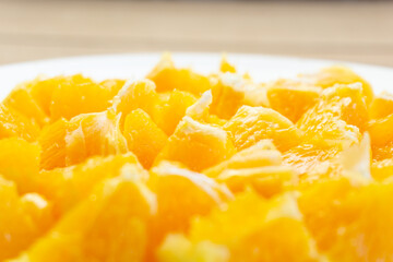 Close-up of fresh cut oranges on a white plate with the background out of focus
