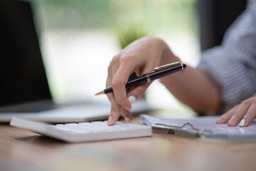 Close-up Of A Businessperson's Hand Calculating Bill With Calculator.