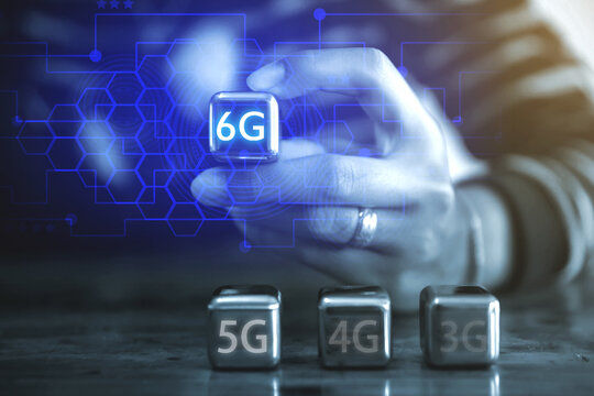 6G Internet and network technology concepts A young businessman using a square steel ball hand and sees the inscription: 6G using a steel ball mobile.