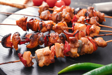 Board with tasty chicken kebab on table