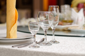 Three empty glasses for alcoholic beverages of vodka, wine and champagne are on the table