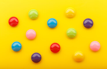 Yellow abstract background with round multicolored drops or buttons buttons. Bright modern abstract background with copy space