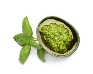 Bowl with fresh pesto sauce and basil leaves on white background