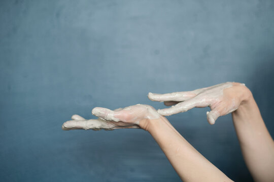 female hands clotted mud clay play cheerfully and show hands. Hands dirty