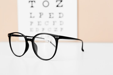 Stylish eyeglasses on table, closeup