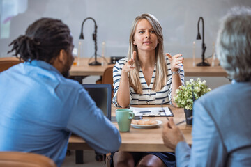 Female manager discussing business. Group of people on a business meeting. Portrait of cheerful businesswoman discussing and smiling at the meeting with colleagues