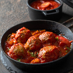 Stewed meatballs in tomato sauce in frying pan.